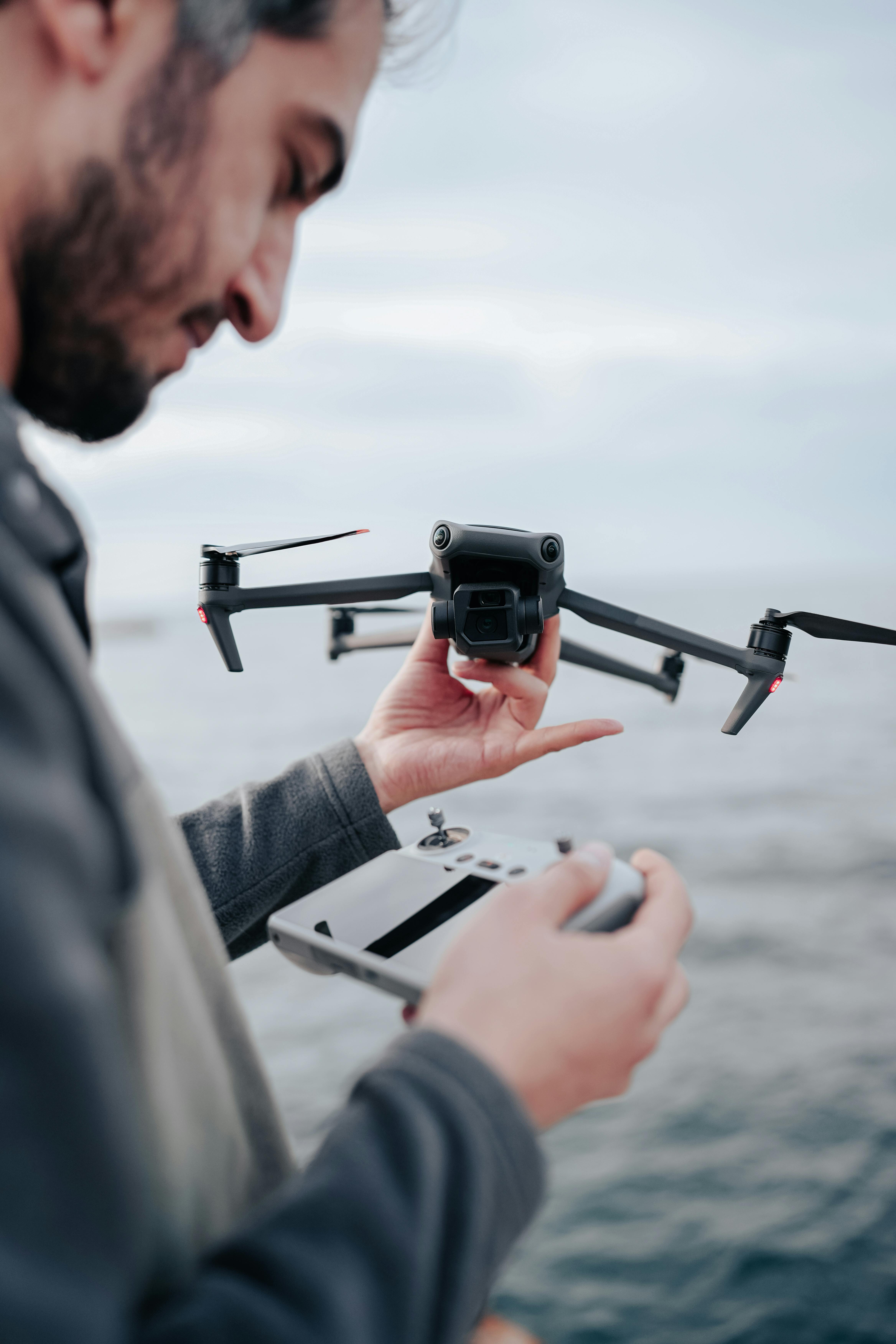 Operator field-testing the drone with its controller at the coast